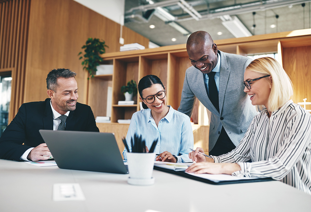 Diverse group of businesspeople laughing together during an office meeting